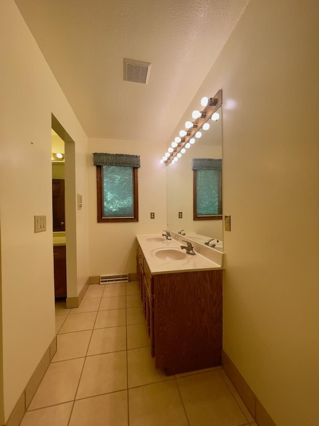 bathroom featuring a textured ceiling, vanity, and tile patterned floors