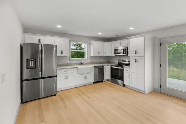 2490 Stream View Ln, Morristown, TN 37814 - kitchen featuring stainless steel appliances, light wood-style flooring, white cabinets, recessed lighting, and light stone countertops