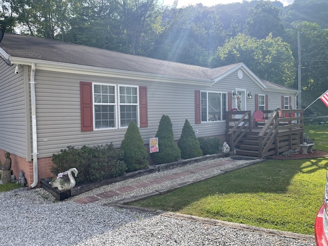 view of front of property featuring a front yard and a wooden deck