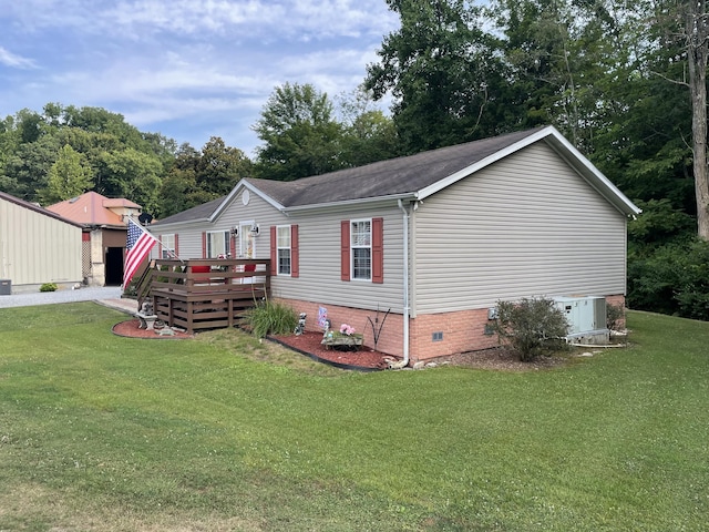 manufactured / mobile home featuring a wooden deck and a front lawn