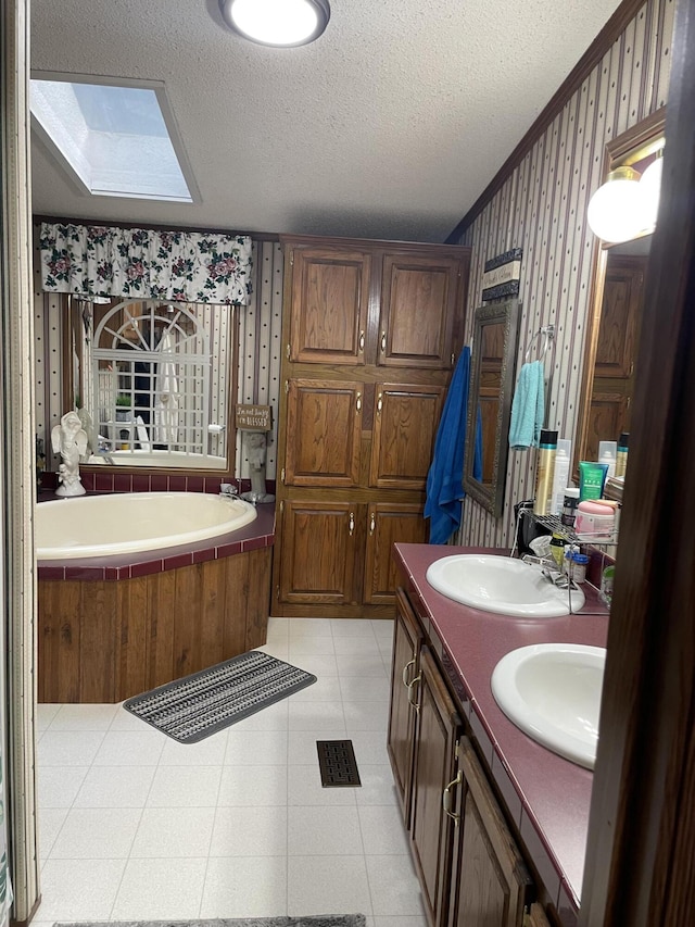 bathroom featuring a skylight, a bathtub, ornamental molding, vanity, and a textured ceiling