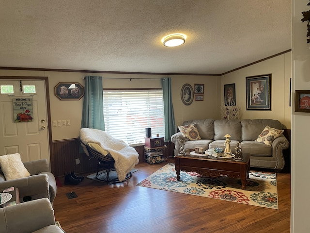 living room featuring a textured ceiling, hardwood / wood-style flooring, and crown molding