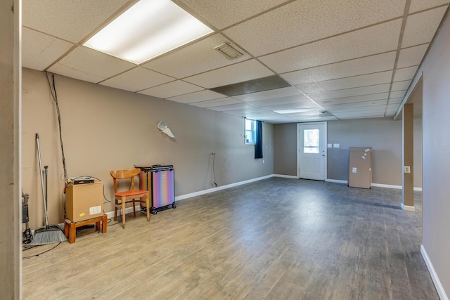 basement featuring a paneled ceiling and wood-type flooring