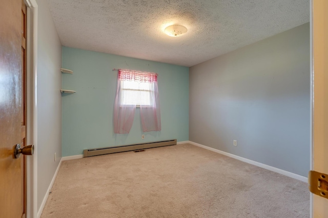 carpeted empty room with a textured ceiling and a baseboard heating unit