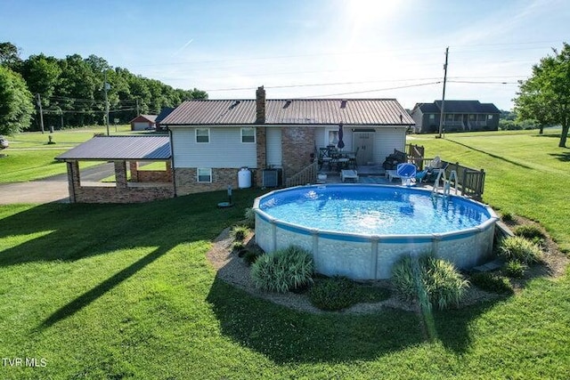 view of pool with a yard and central AC