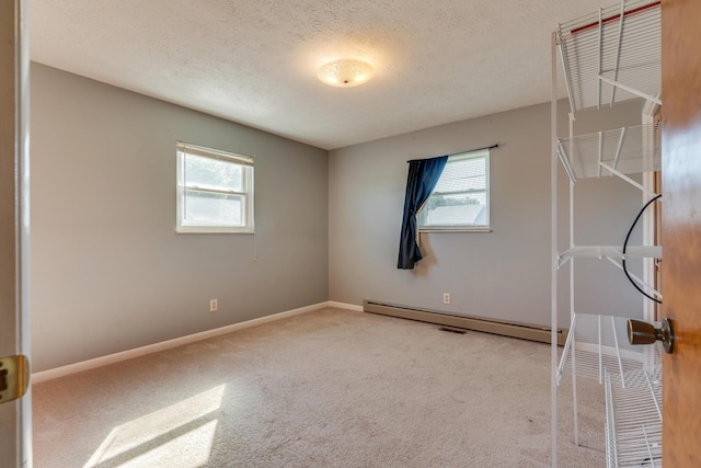 empty room with carpet flooring, a baseboard radiator, and a textured ceiling