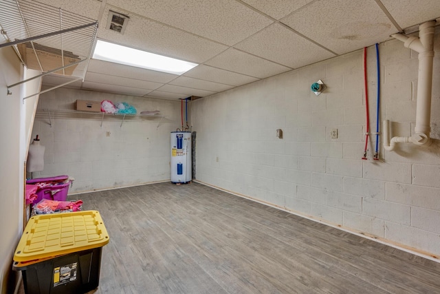 basement with electric water heater, a drop ceiling, and hardwood / wood-style flooring