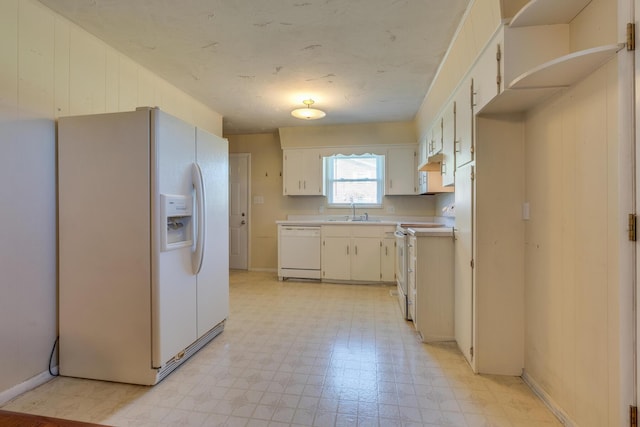 kitchen featuring premium range hood, white cabinetry, sink, and white appliances