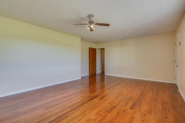 unfurnished room with wood-type flooring, a textured ceiling, and ceiling fan