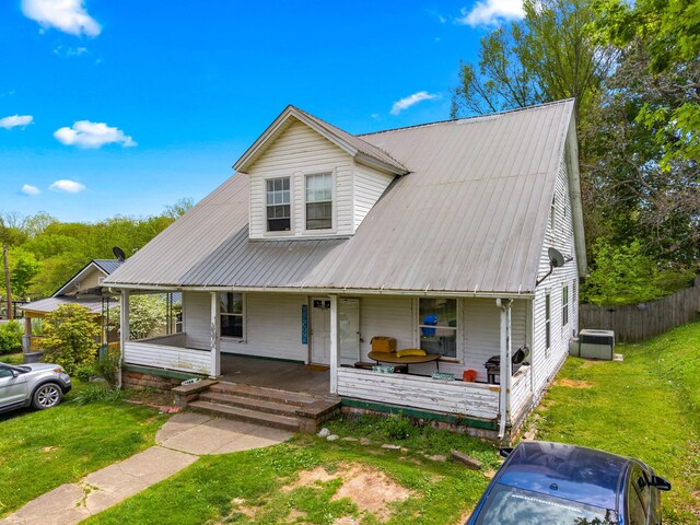 back of property with covered porch and a yard