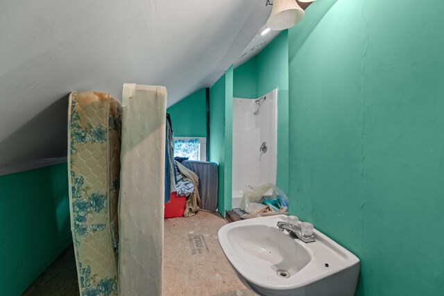 bathroom featuring lofted ceiling and a sink