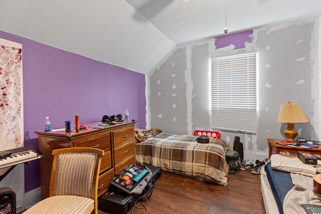 bedroom featuring wood finished floors and lofted ceiling
