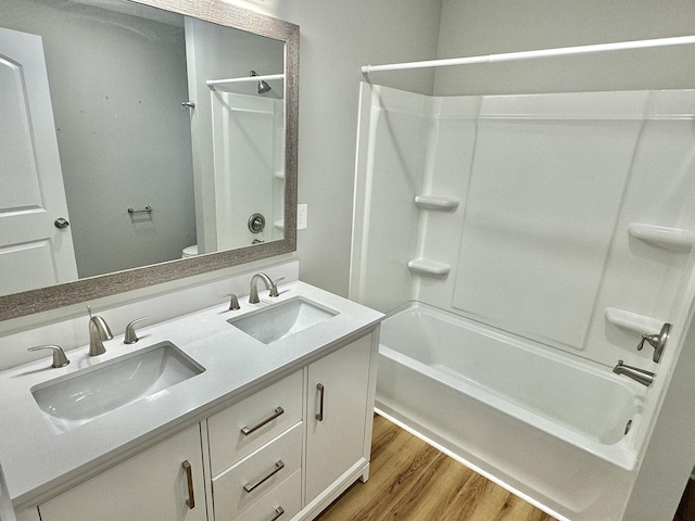 full bathroom featuring hardwood / wood-style floors, vanity, toilet, and washtub / shower combination