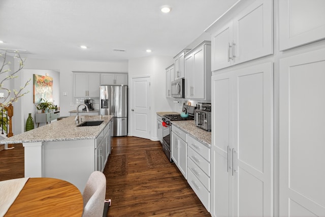 3059 Berna Way, Morristown, TN 37814 - kitchen featuring stainless steel appliances, dark wood-type flooring, a center island with sink, recessed lighting, and light stone counters