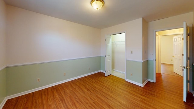 unfurnished bedroom featuring hardwood / wood-style flooring and a closet