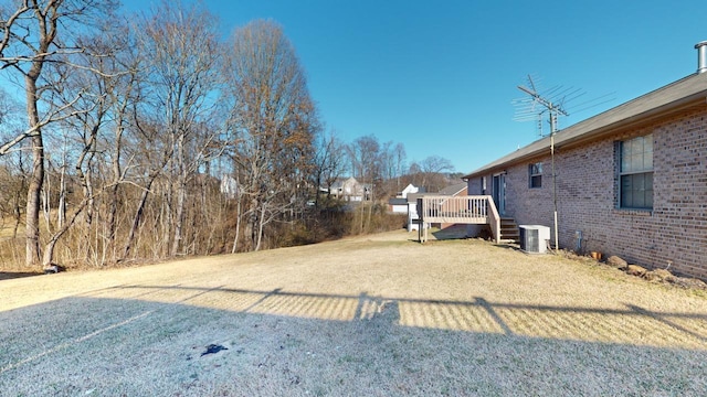 view of yard featuring central AC unit and a wooden deck