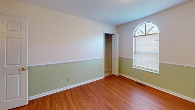 unfurnished bedroom featuring wood-type flooring and a closet