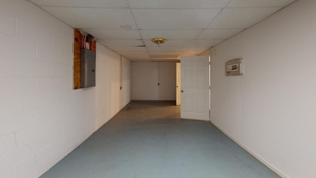 hallway featuring a drop ceiling, electric panel, and concrete floors