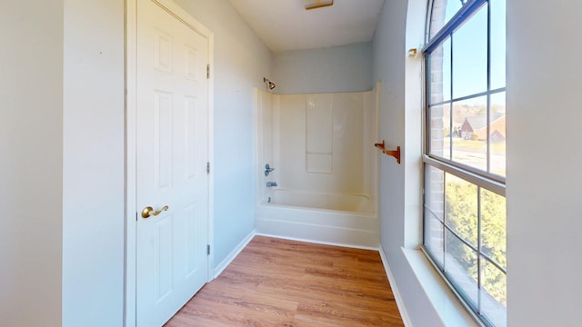 bathroom with hardwood / wood-style flooring and  shower combination