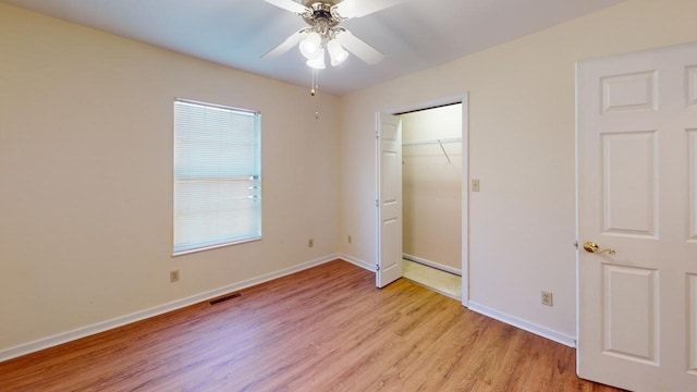 unfurnished bedroom with ceiling fan, light hardwood / wood-style floors, and a closet