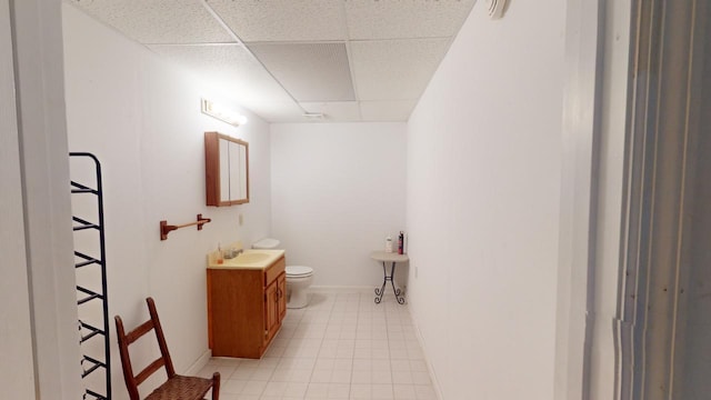 bathroom featuring vanity, a paneled ceiling, tile patterned floors, and toilet