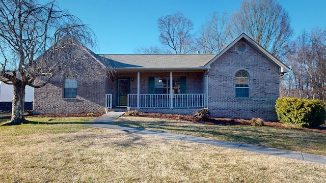 ranch-style house featuring covered porch and a front lawn