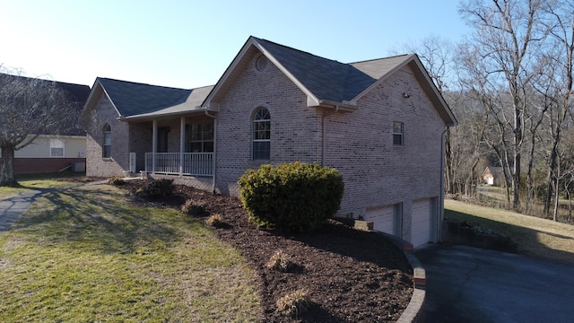 view of property exterior with a garage, a yard, and covered porch