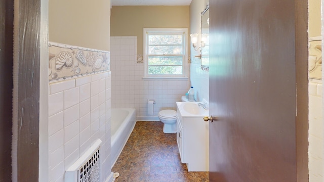 bathroom featuring a tub to relax in, vanity, tile walls, and toilet