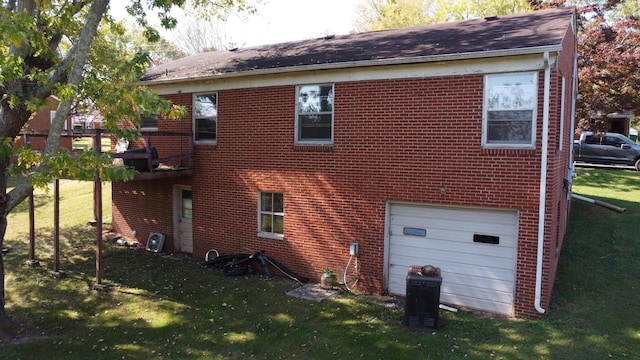 rear view of house featuring a garage and a yard