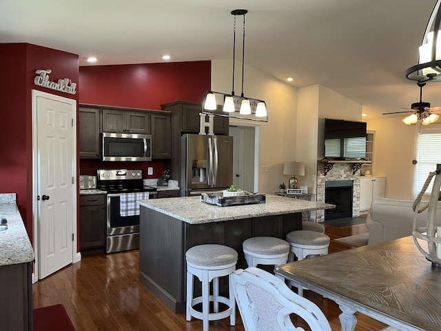 122 Florence Cir, Dandridge, TN 37725 - kitchen with stainless steel appliances, a kitchen island, a breakfast bar area, dark wood-style flooring, and a ceiling fan