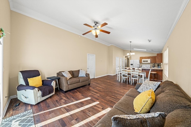 living area featuring ceiling fan with notable chandelier, dark wood-type flooring, baseboards, vaulted ceiling, and crown molding