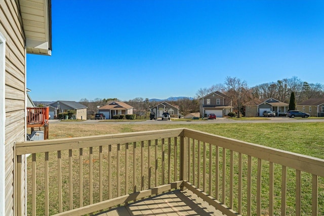 wooden terrace featuring a residential view and a yard