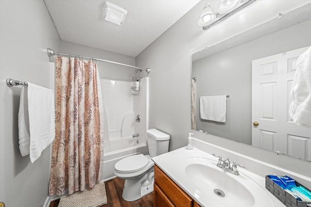 full bath with toilet, vanity, wood finished floors, shower / bath combination with curtain, and a textured ceiling