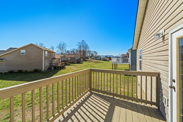 deck with a residential view and a yard