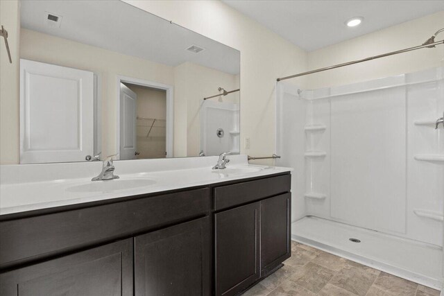bathroom with a shower and vanity