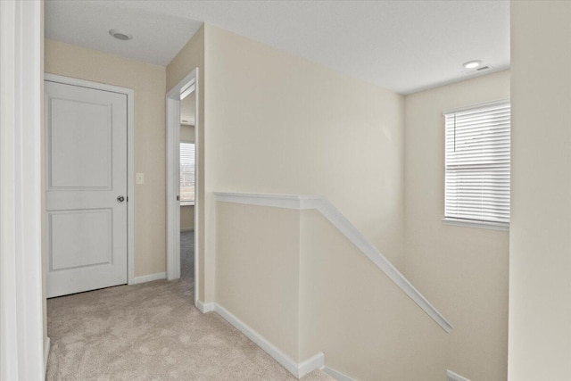 hall featuring light colored carpet