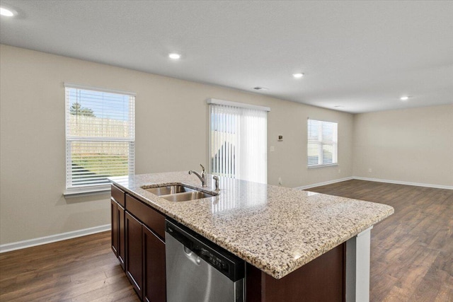 kitchen with an island with sink, sink, stainless steel dishwasher, dark wood-type flooring, and dark brown cabinets