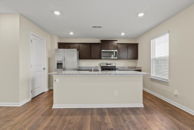 kitchen featuring dark brown cabinetry, dark hardwood / wood-style flooring, stainless steel appliances, and an island with sink