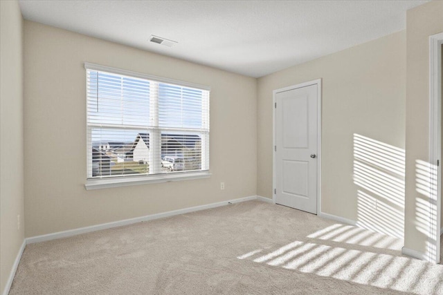 spare room featuring light carpet