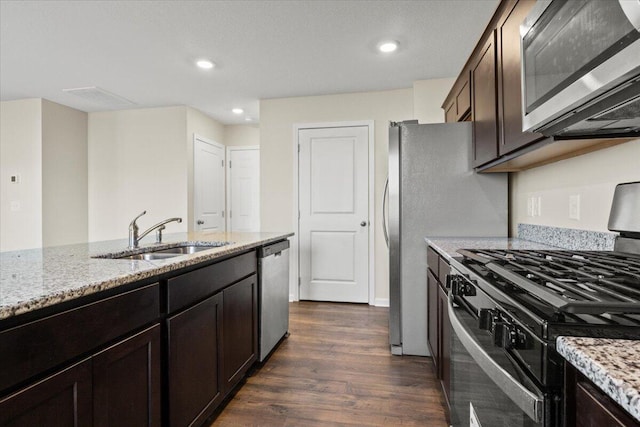 kitchen featuring dark hardwood / wood-style floors, sink, light stone counters, stainless steel appliances, and dark brown cabinets