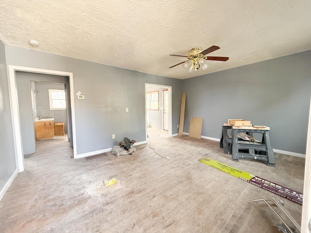 interior space with a textured ceiling and ceiling fan