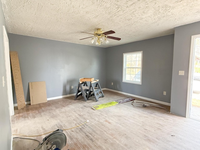 interior space with a textured ceiling and ceiling fan