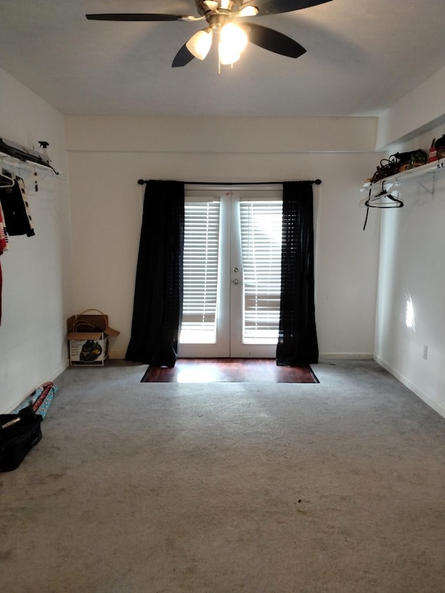 empty room featuring ceiling fan, french doors, and carpet