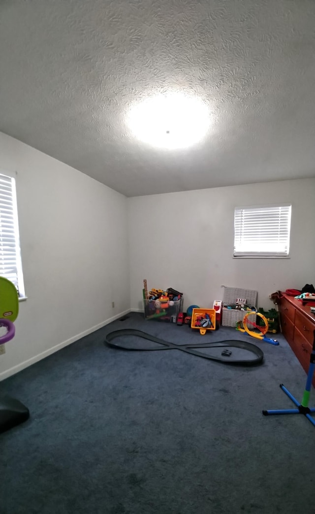 playroom with carpet and a textured ceiling