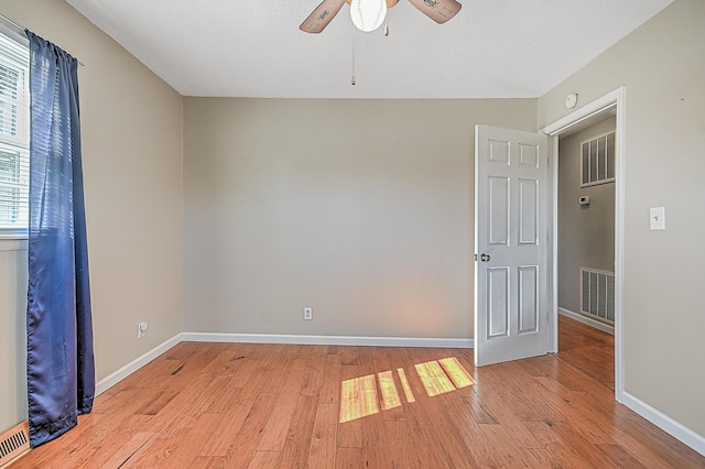 spare room featuring a textured ceiling, ceiling fan, and light hardwood / wood-style flooring