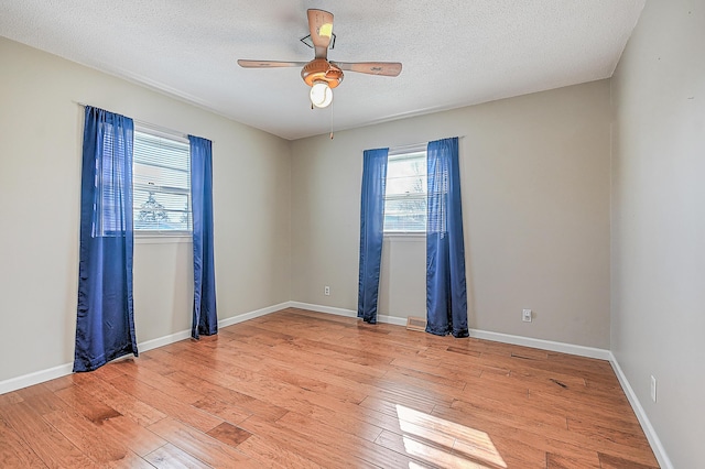 spare room featuring a textured ceiling, ceiling fan, and light hardwood / wood-style flooring