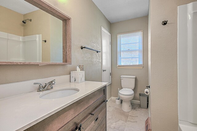 bathroom featuring vanity, toilet, and walk in shower