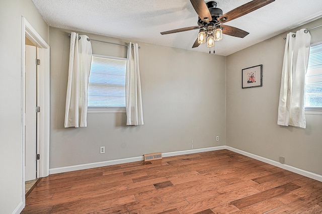 empty room featuring ceiling fan, a textured ceiling, and light hardwood / wood-style floors