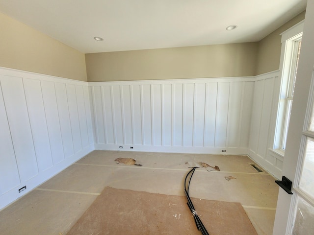 unfurnished room featuring a wainscoted wall