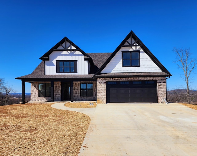 view of front facade with a garage, roof with shingles, concrete driveway, and brick siding